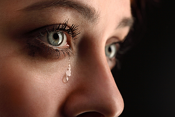 Close-up of female eyes with tears running down