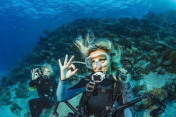 Scuba diver is exploring and enjoying Coral reef  Sea life Couple Two sporting women Underwater photographer